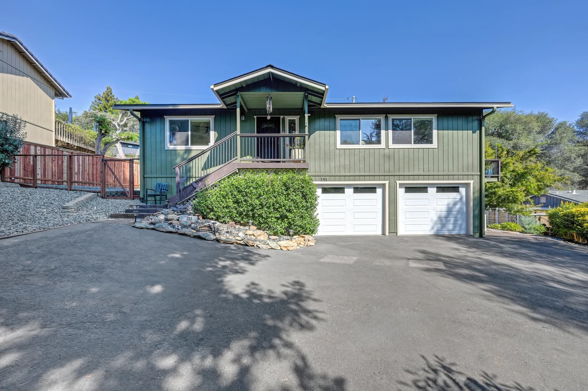 Front exterior with elevated entry, stairs and two garage doors at 153 Russell Rd, Auburn