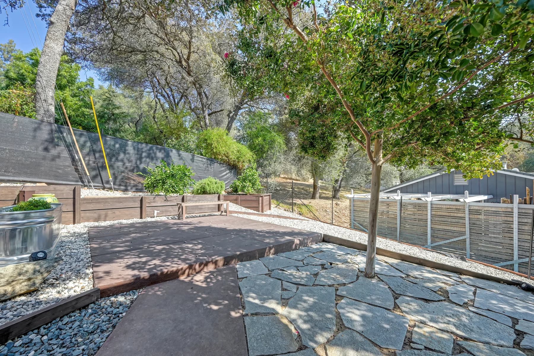 Terraced backyard with outdoor seating and trees at 153 Russell Rd, Auburn