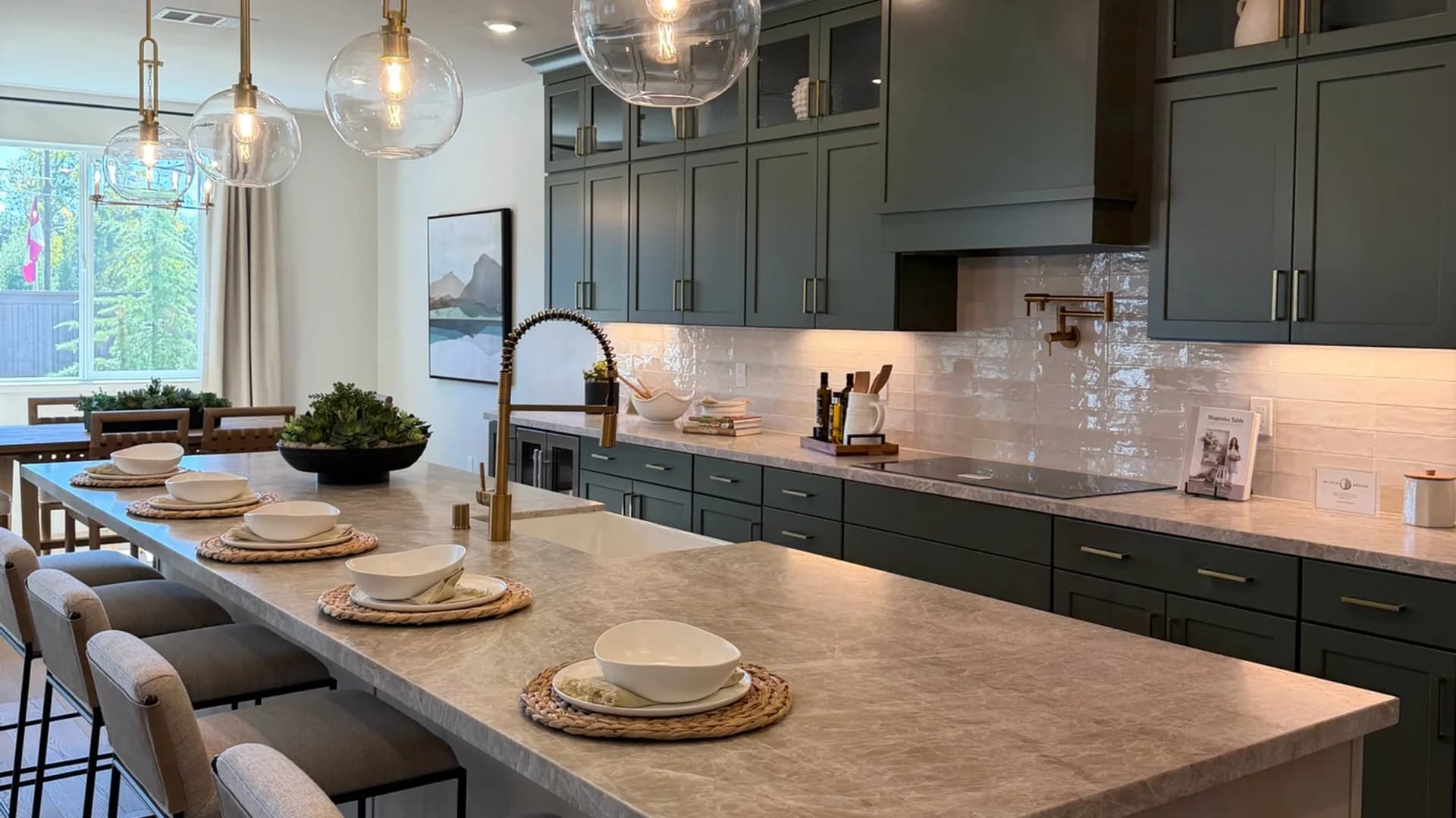 Kitchen in a Blossom Ridge model home in Orangevale with green cabinetry, a large island, and pendant lighting