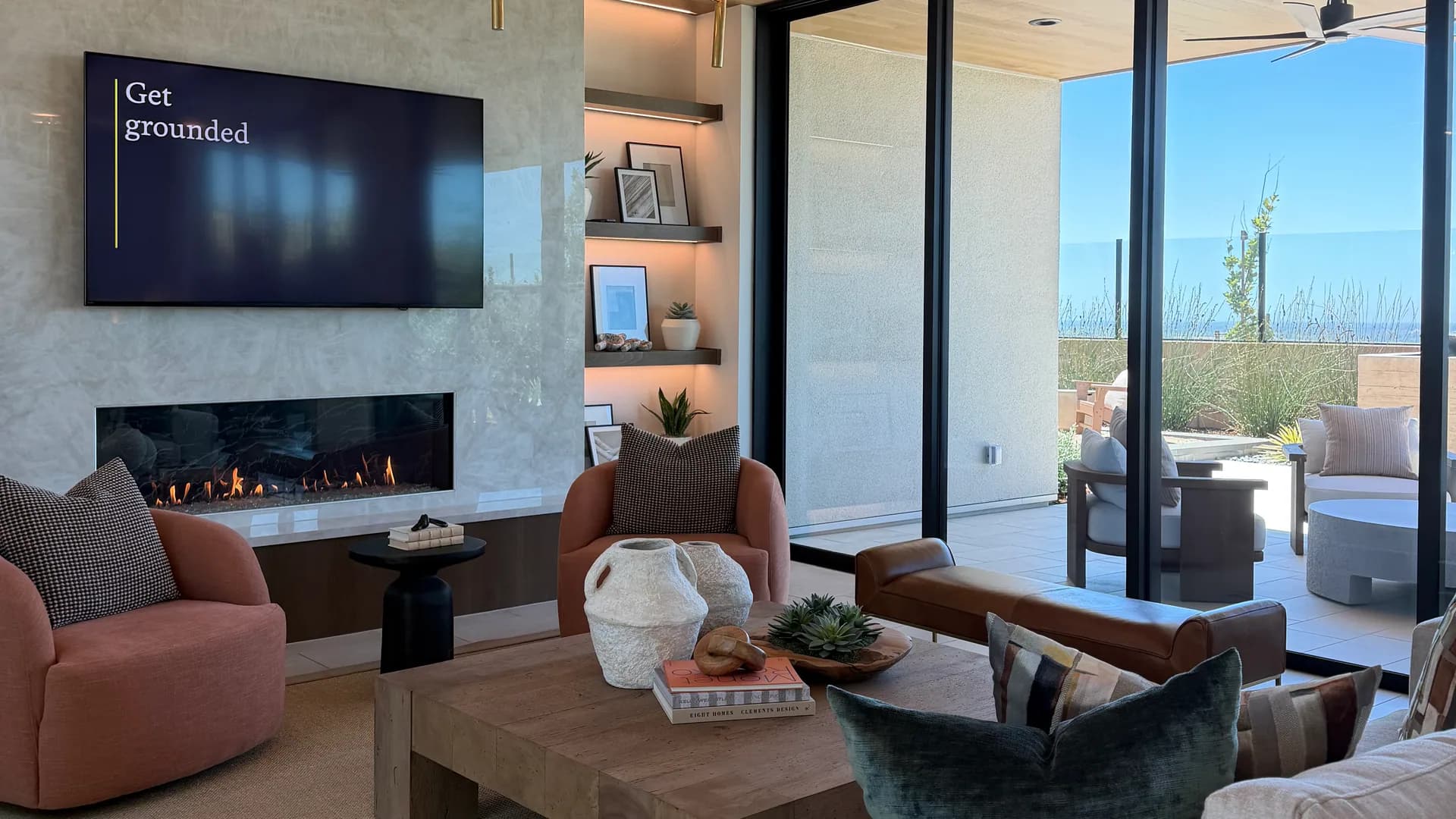Great room in a SHAWOOD at Folsom model home with exposed beams, fireplace, and glass doors to a covered patio