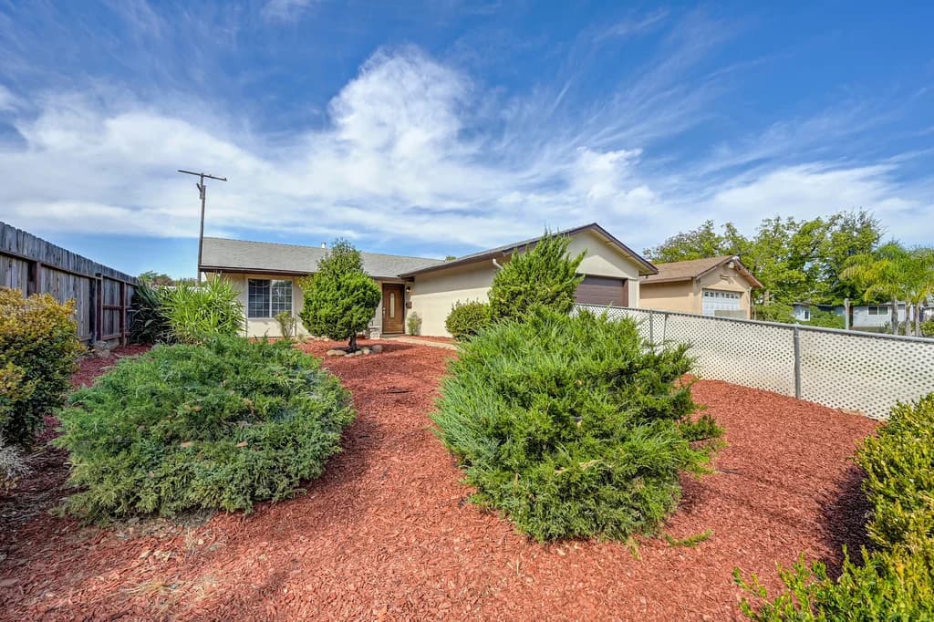 Front exterior and landscaped approach at 10229 S White Rock Rd