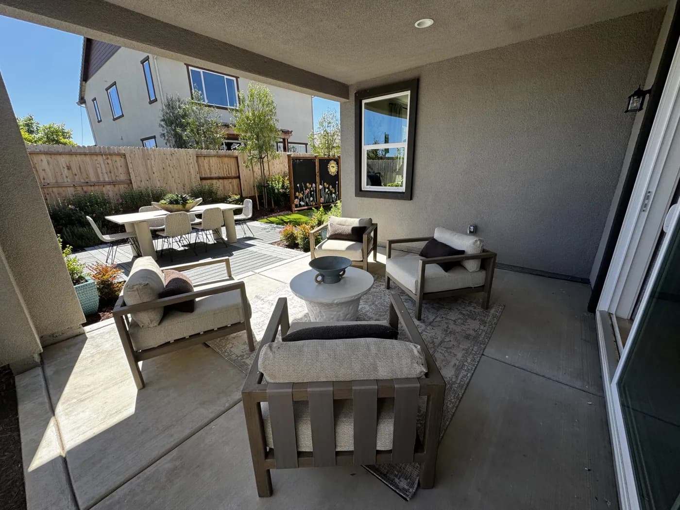 Covered outdoor patio at Amoruso Ranch with lounge seating and views of the backyard