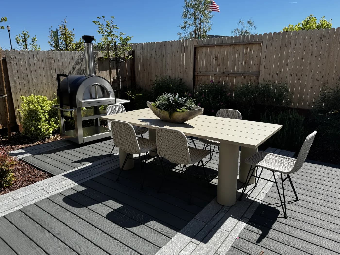 Backyard dining area at Amoruso Ranch with composite deck, dining table, and built-in pizza oven