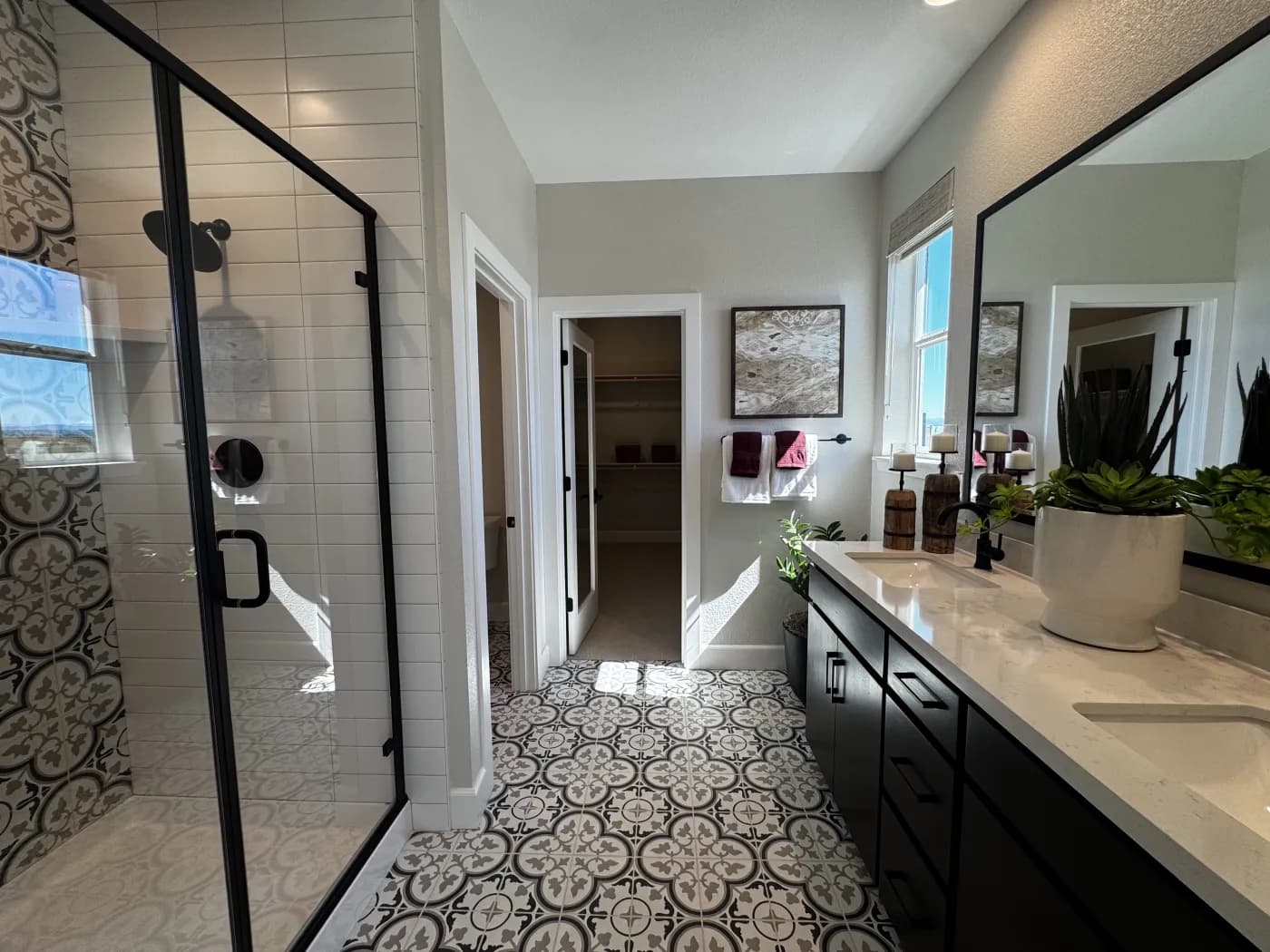 Primary bathroom at Amoruso Ranch with walk-in glass shower, double vanity, and patterned encaustic floor tile